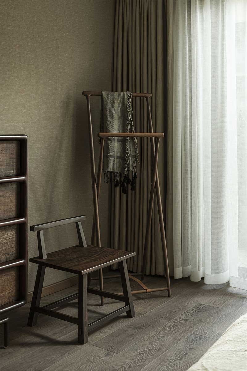 精美的木質斗柜與座椅、掛衣架，柔雅與硬朗并存，簡樸內斂，閃著溫潤的色澤，將空間的“木語”敘說到極致。