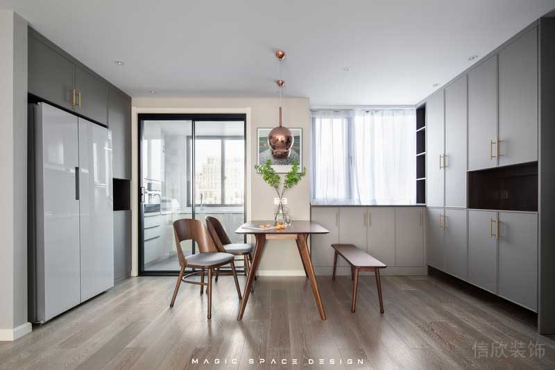 因為廚房格局較小，所以體積龐大的雙開門冰箱被安置在外部的定制柜內，平日里在客廳休息時取用放置也很方便。