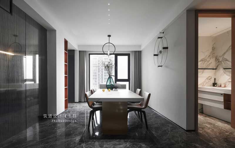 設計師通過墻面的大面積留白、吊頂的簡單處理以及墻面上簡單的裝飾畫和掛件，讓餐廳與全屋的風格統一，同時在空間中添加了與客廳同色調的家具作為點綴，讓人在用餐時不僅能夠刺激食欲，還能感受到家的溫馨。