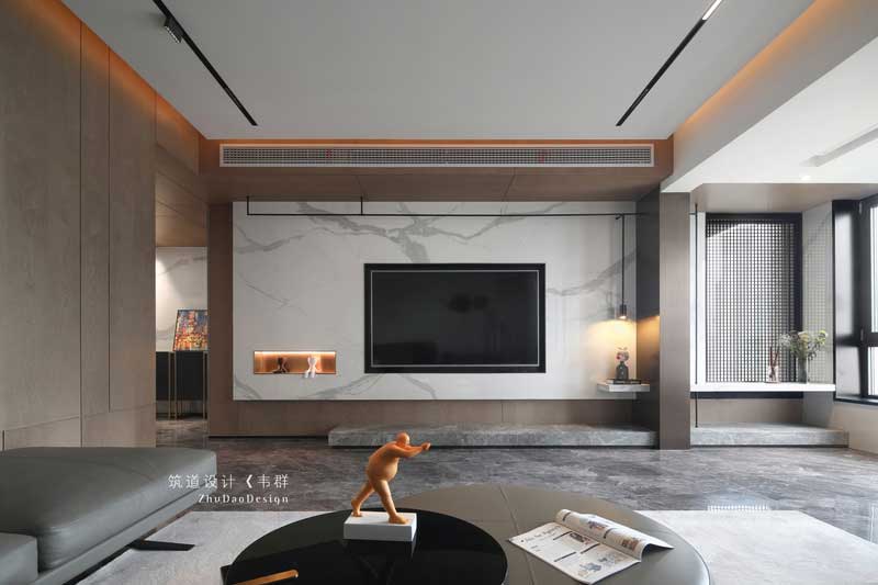 設(shè)計師巧妙地運用色彩和燈光，把看似獨立的空間完全打開并融于整體。木色的護墻、簡潔的裝飾、大理石電視背景以及擺放家具中夾雜的跳色的點綴，將原本素雅大氣的空間變得有了些許生活氣息。